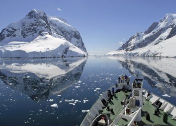 A small cruise ship makes passage through the Lemaire Channel in Antarctica