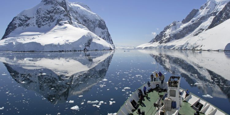 A small cruise ship makes passage through the Lemaire Channel in Antarctica