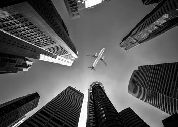 Avião entre prédios preto e branco