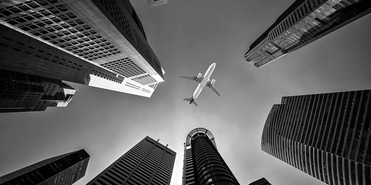 Avião entre prédios preto e branco