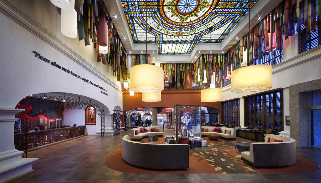Salão de checkín do Hard Rock Hotel Riviera Maya, da RCD Hotels, com lustres pendurados no teto, revestido por vitrais coloridos