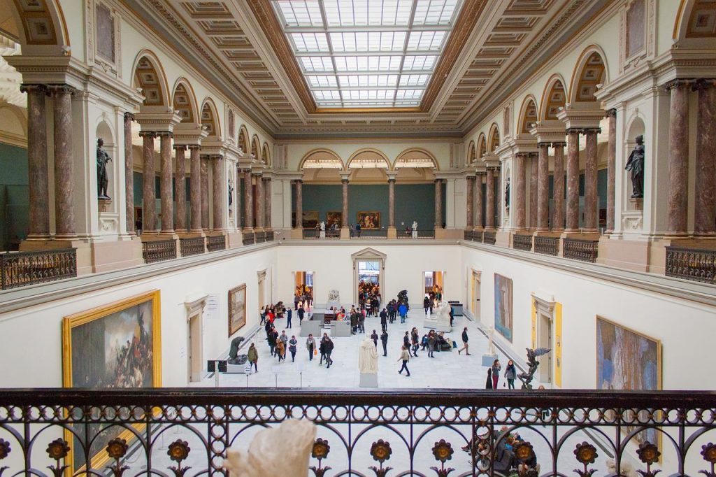 Interior de museu em estilo arquitetônico clássico, ambiente iluminado e obras de arte em exposição